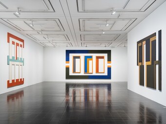 Moderne Kunstgalerie mit abstrakten Gemälden an weißen Wänden und dunklem Boden