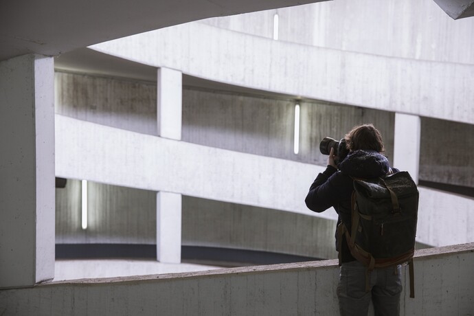 Person fotografiert moderne Architektur mit geometrischen weißen Betonformen