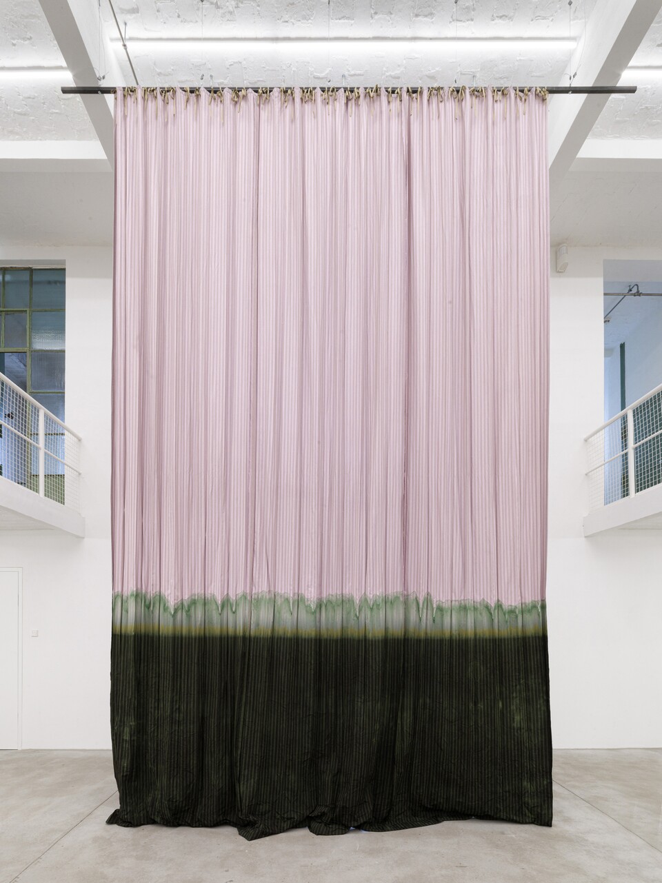 Großer Vorhang in Rosa und Schwarz hängt in einem weißen Galerieraum