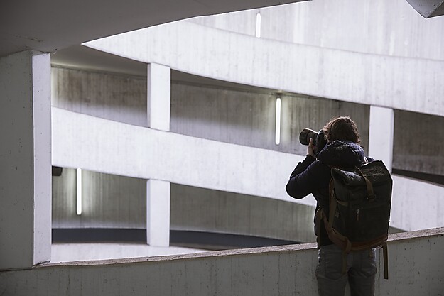 Person fotografiert moderne Architektur mit geometrischen weißen Betonformen